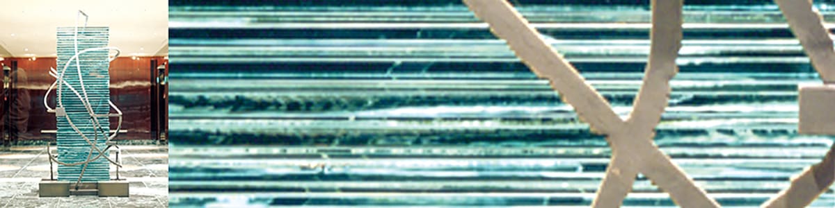 磨きあげられたマホガニーで覆われたホールに、透明板ガラスを積層した2メートルほどの塊（雨）をバーナーで溶断したブロンズ色のスチール（雲）が覆う彫刻を制作した